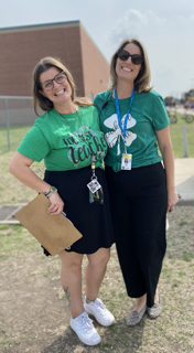 photo of two staff members wearing green